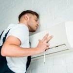 handsome worker installing air conditioner